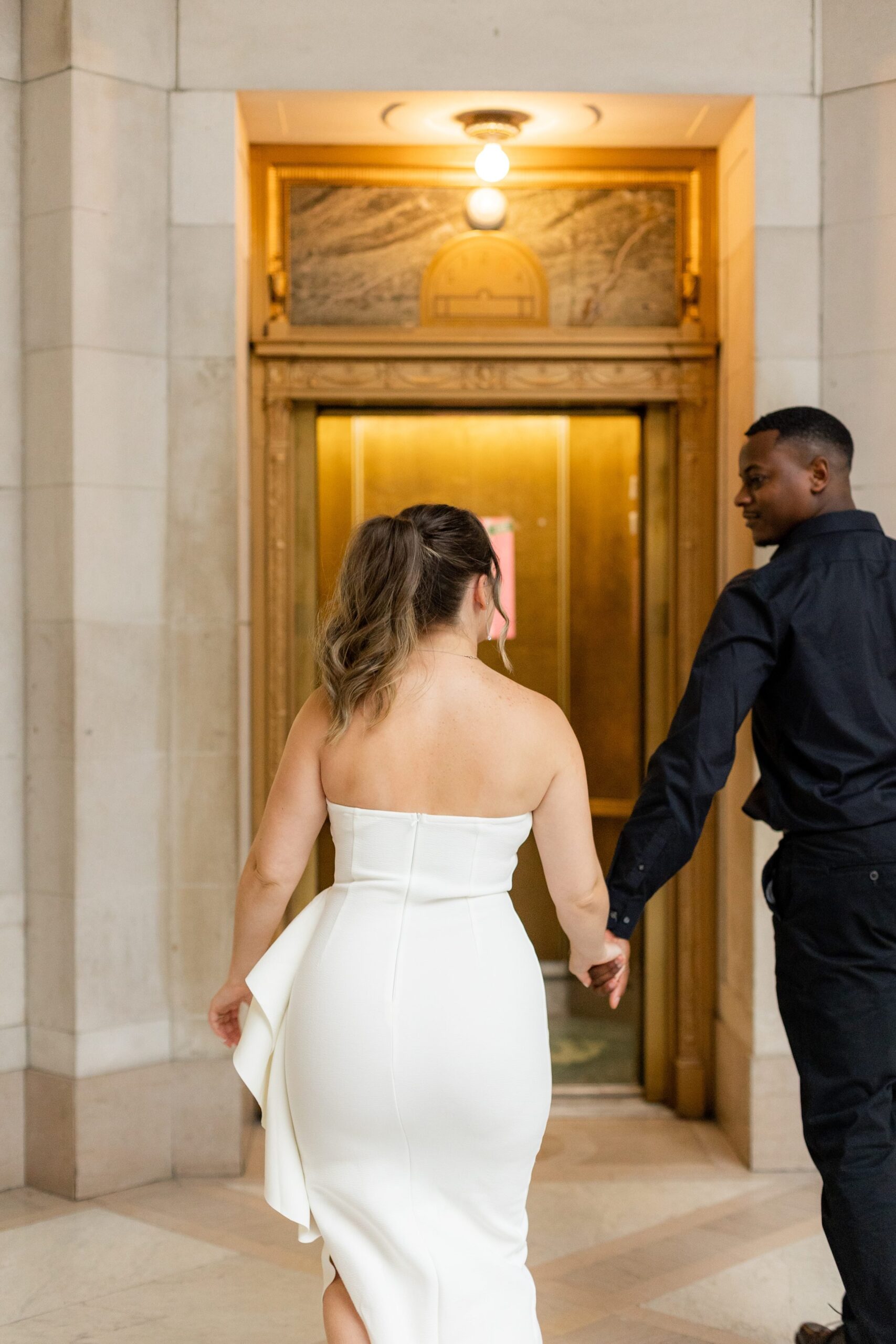 Couple walking into historic elevator at City Hall 