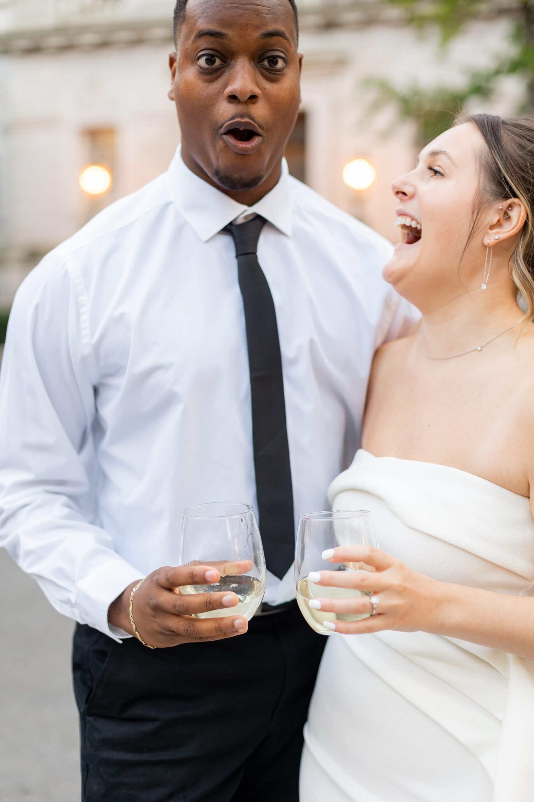 Couple popping champagne during engagement photos at Hartford City Hall