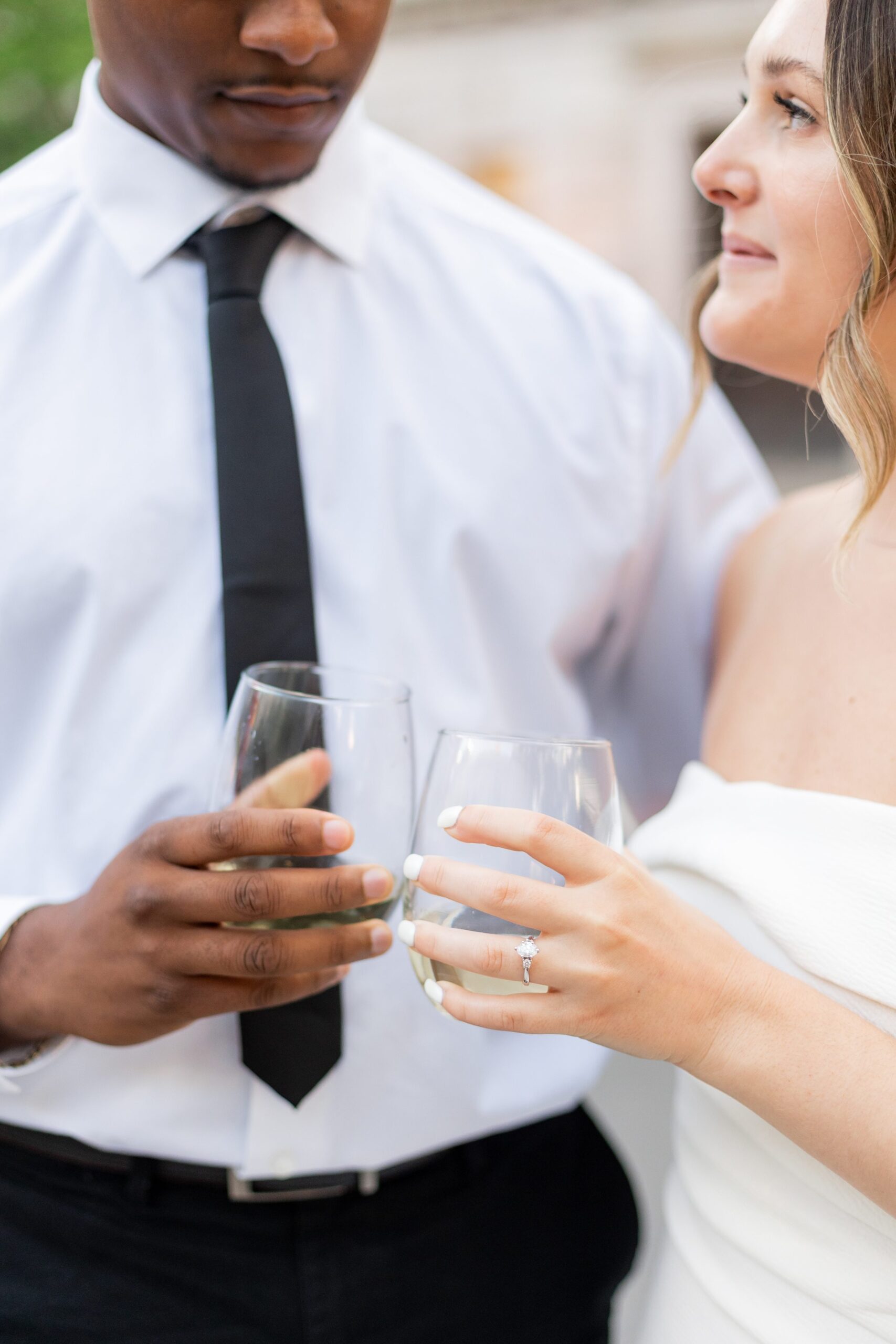 Couple popping champagne during engagement photos at Hartford City Hall